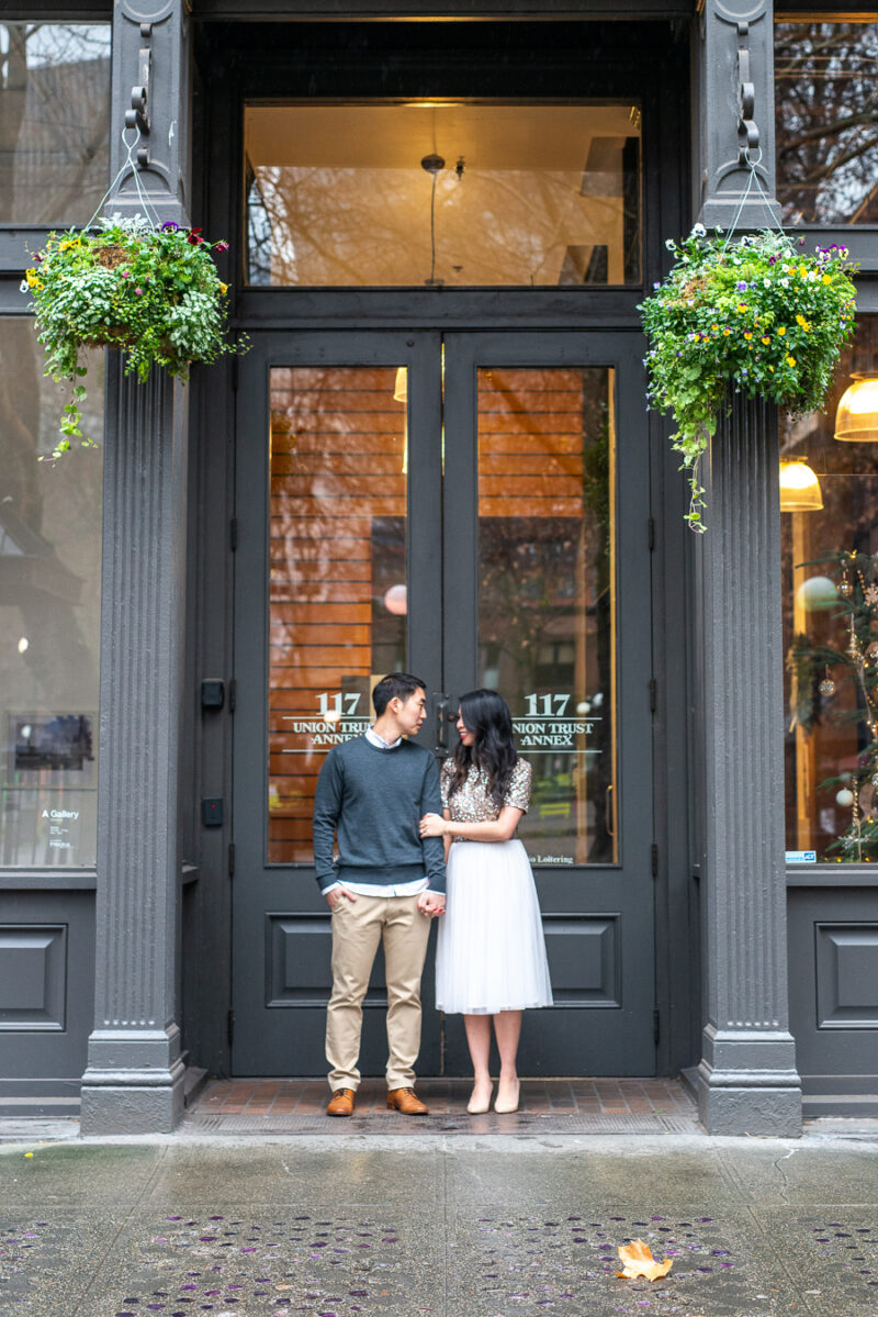 Seattle engagement photos in Pioneer Square, Occidental Park, holiday shoot, rainy engagement photos with clear umbrella, Seattle fashion blogger Just A Tina Bit, midi tulle skirt, embellished top, sequined top