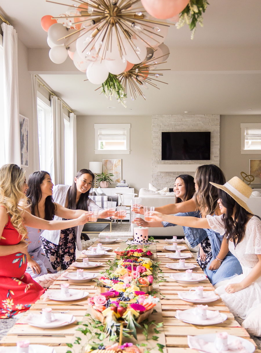 Picnic bridal shower with wood pallets, balloon garland, exotic fruit platters, table setting with mini rose boxes as party favors
