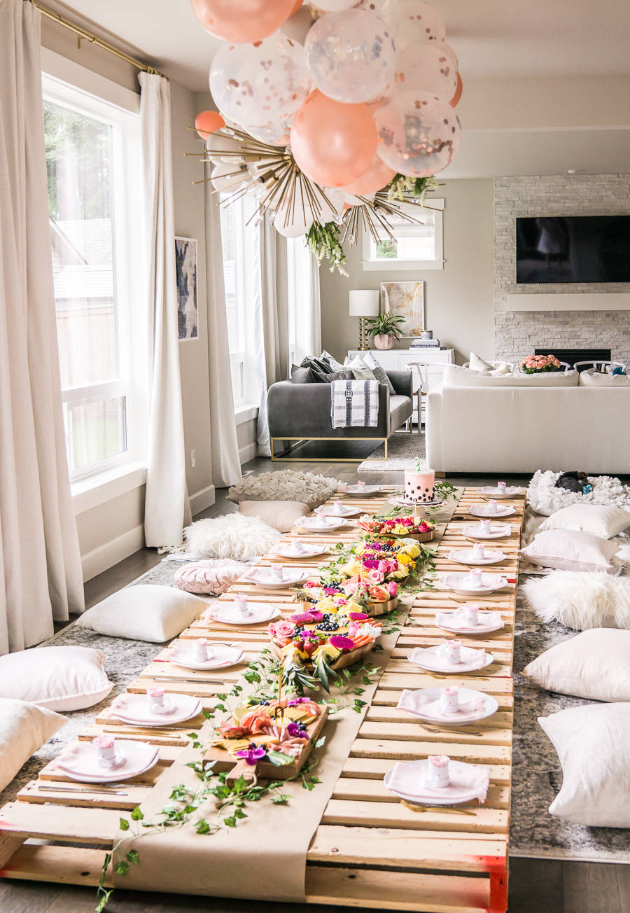 Picnic bridal shower with wood pallets, balloon garland, exotic fruit platters, table setting with mini rose boxes as party favors, cushions