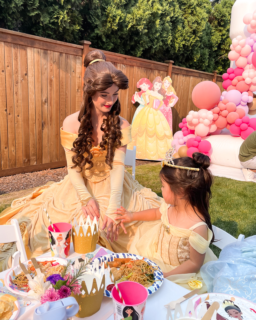 Disney princess table setting, princess party decor with paper plates, crown bowls, kids chairs, white bounce house